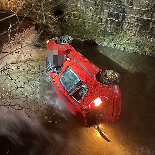 Auto po nehodě skončilo na boku v řece, zraněného řidiče zachránili hasiči